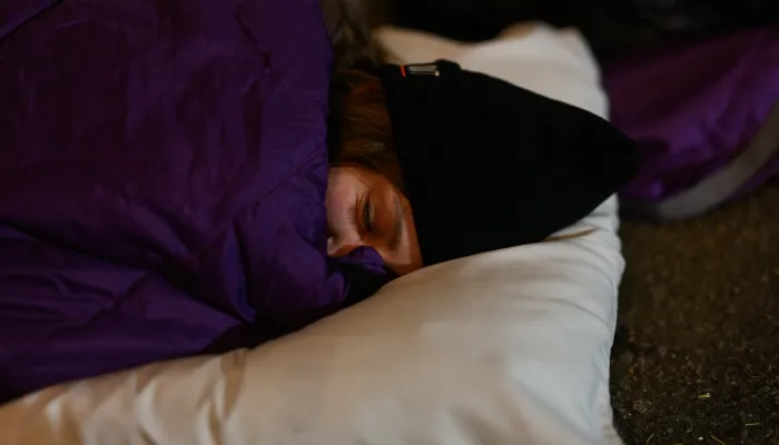 woman in sleeping bag sleeping on pillow