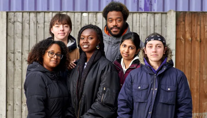 Group of six young people stand together