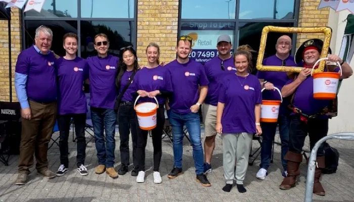 10 members of the Bellrock Group in purple Centrepoint T Shirts with collection buckets