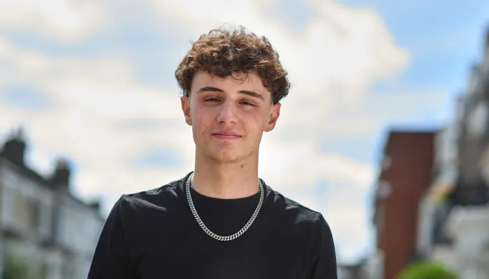 Young person standing outside and looking directly at camera