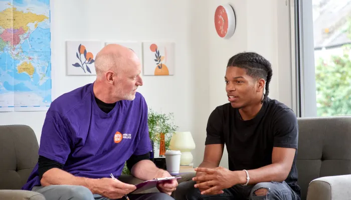 A young person in supported housing talks to a Centrepoint staff member