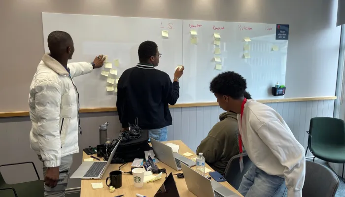 Young people take part in a workshop with Nationwide and post ideas on a whiteboard