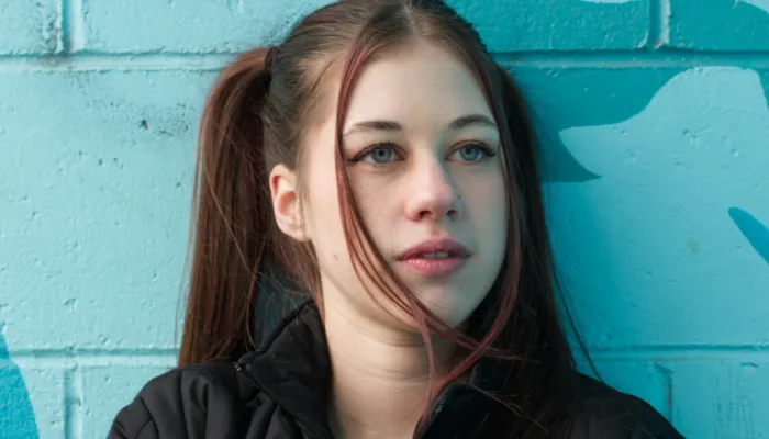 Young woman in front of blue wall