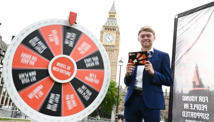 Gameshow hosts stands by a wheel