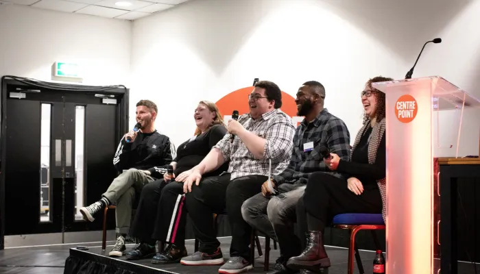 A group of speakers laughing during their talk on stage