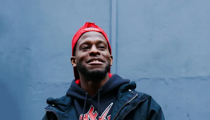 Young man in a red hat standing in front of a wall
