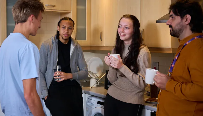 Young people and a support worker having a coffee