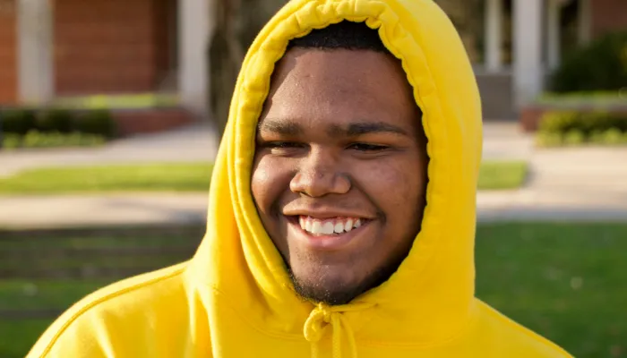Young man smiling in a yellow jumper