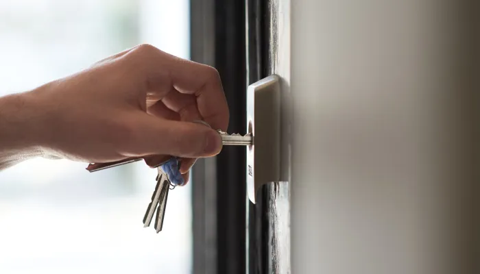 Hand opening a lock in a door 