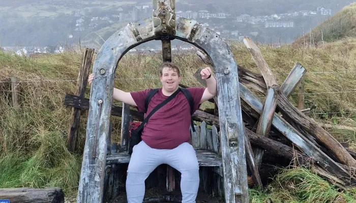 Young man sat on a wooden bench