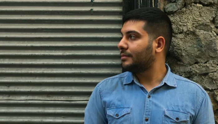 Man standing in front of wall looking to the side