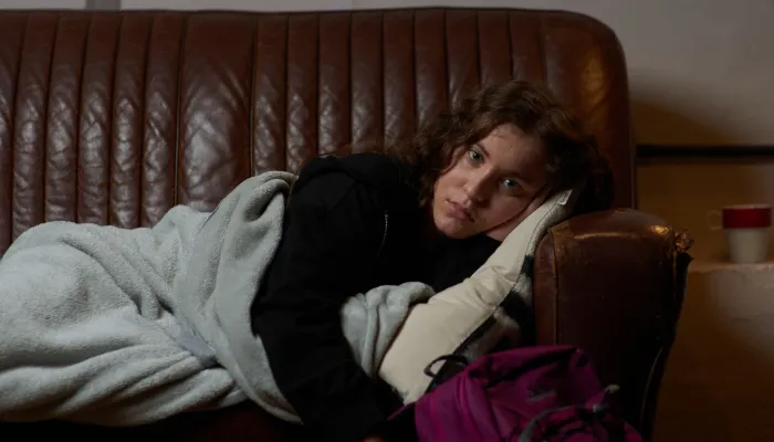 Young person sleeping on friend's sofa