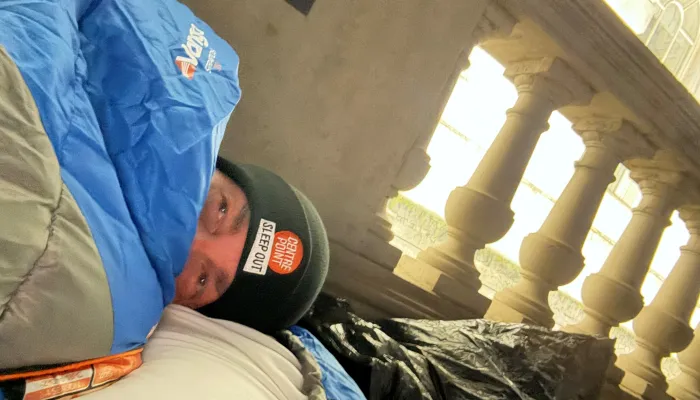 Sleep Out participant in sleeping bag with sleep out hat