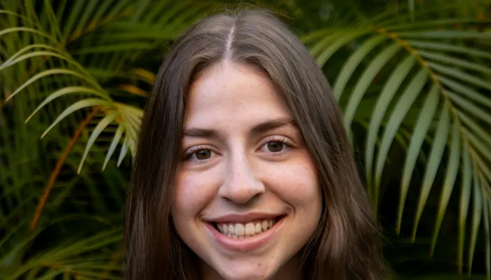 Young woman smiling in front of green plants