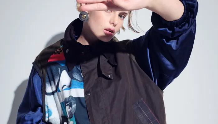 Model holding her hand up to the light wearing a gillet