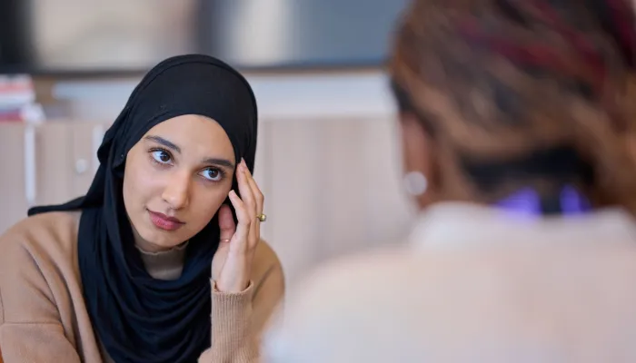A nervous young woman speaks to a Centrepoint advisor for support
