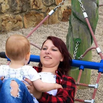 Person on hammock holding baby