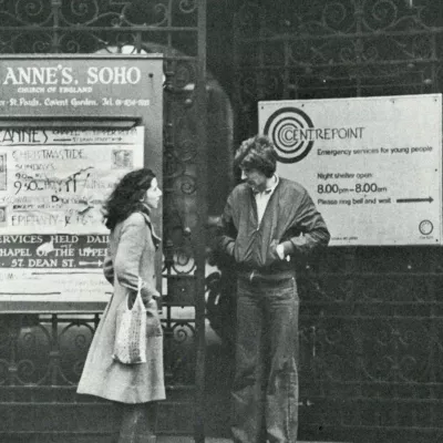 Black and white photograph showing two people outside Centrepoint at St. Anne's Soho in the 1980s