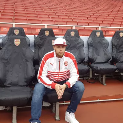 Person sitting alone in Arsenal football stadium