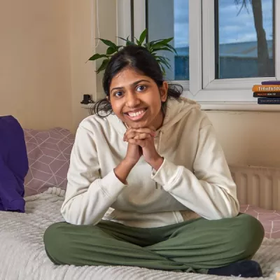 Young person looking happy in their bedroom