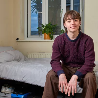 Young person sat on a bed