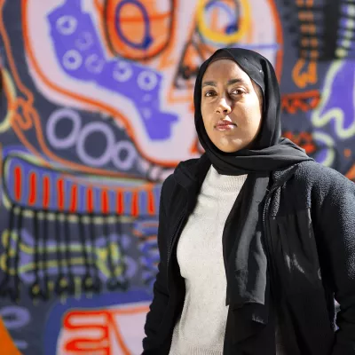 Young person standing in front of graffiti wall