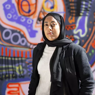 Young person in front of wall with graffiti