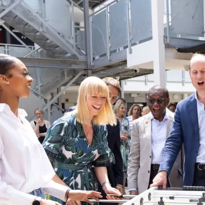 HRH Prince William and Sara Cox playing table football with young people