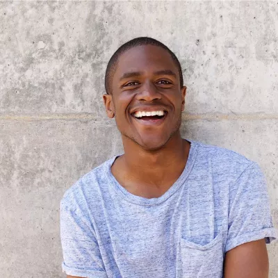 Young person in a light blue t-shirt against a grey wall