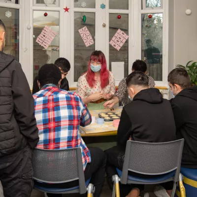 Kim-Joy sits and decorates cupcakes with Centrepoint residents at Christmas