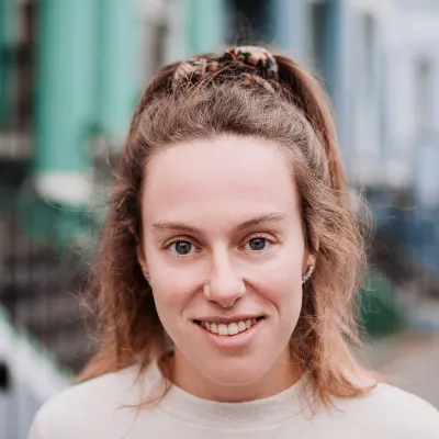 Young person smiling on a colourful residential street