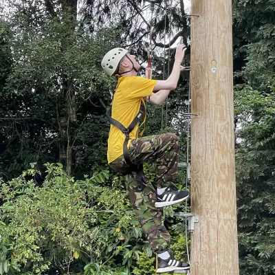 Young person climbing a long post