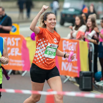 A supporter running in an orange Centrepoint sports t-shirt