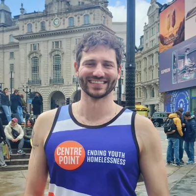 Alexander Lincoln in central London, wearing a Centrepoint running vest and smiling after the London Marathon