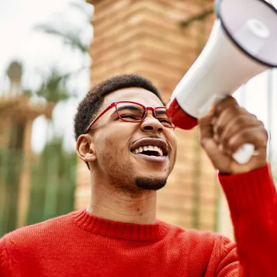 A young man holds a megaphone at a protest