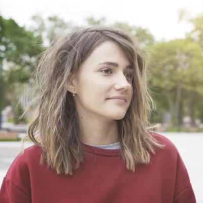 Young person in red sweatshirt looking to the side