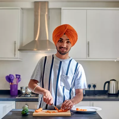 A young person prepares some healthy food in a homely kitchen