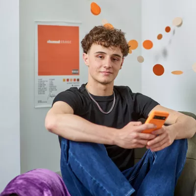 A young person sits in his Centrepoint room looking relaxed