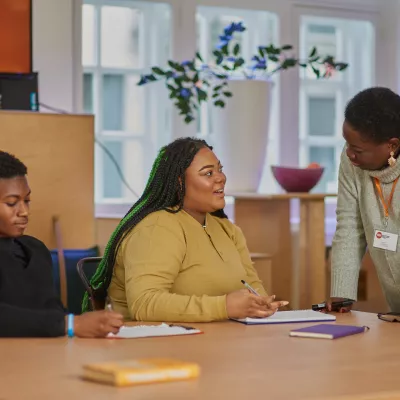 Young people sit in a classroom speaking to a teacher