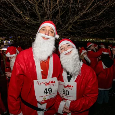 Two people dressed as Santa