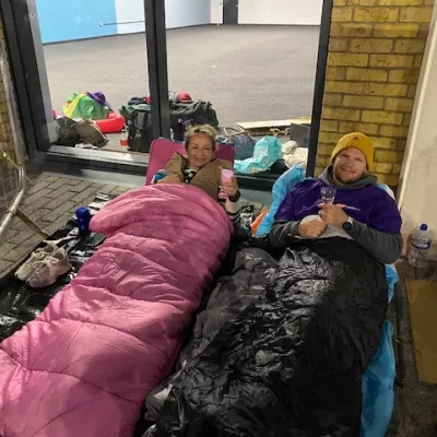 Two colleagues lie on the ground in sleeping bags