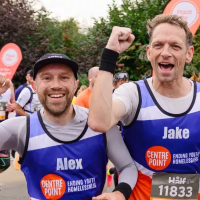 Alex and Jake cheer as they run a marathon wearing Centrepoint running vests