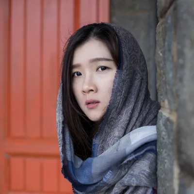 Young women coming round the corner of an alley entrance, looking directly at viewer.