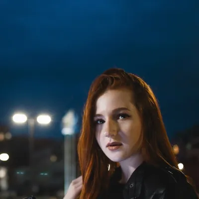 Young women out at night, street lights in the background.