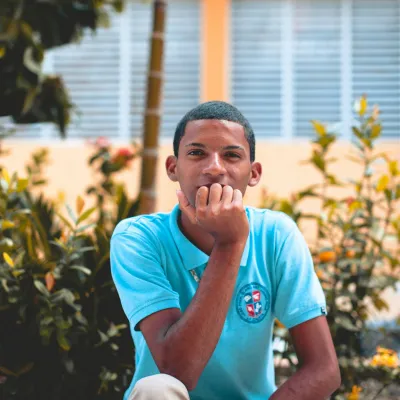 Young man sitting outside looking into camera