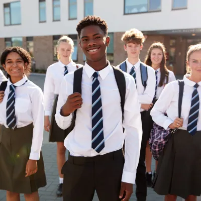 A group of secondary school students stand together in the playground