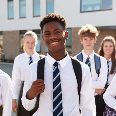 A group of secondary school students stand in the playground