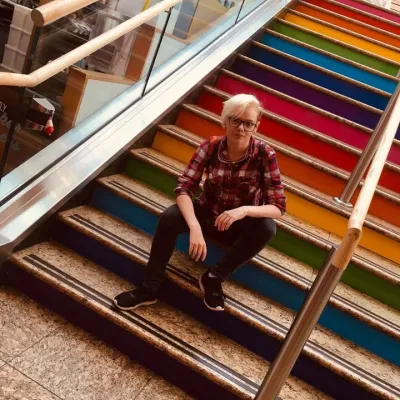 Young person sat on rainbow stairs