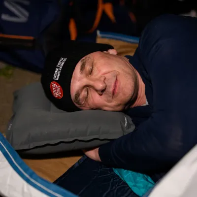 A Sleep Out supporter gets ready to sleep in his sleeping bag