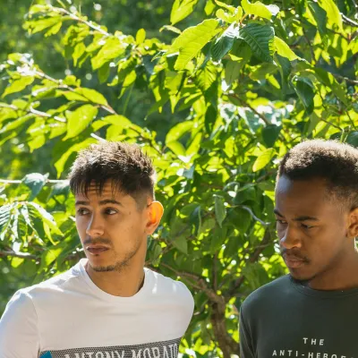 Young men standing in front of a tree
